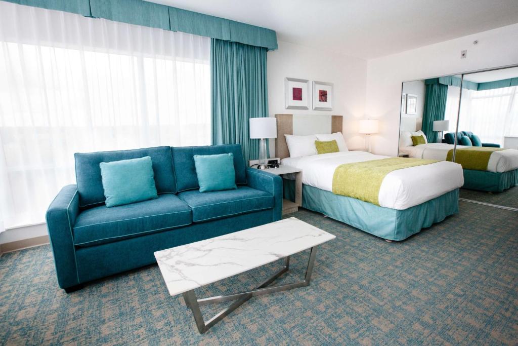 a hotel room with a bed and a couch at Coast Hotel & Convention Centre in Langley