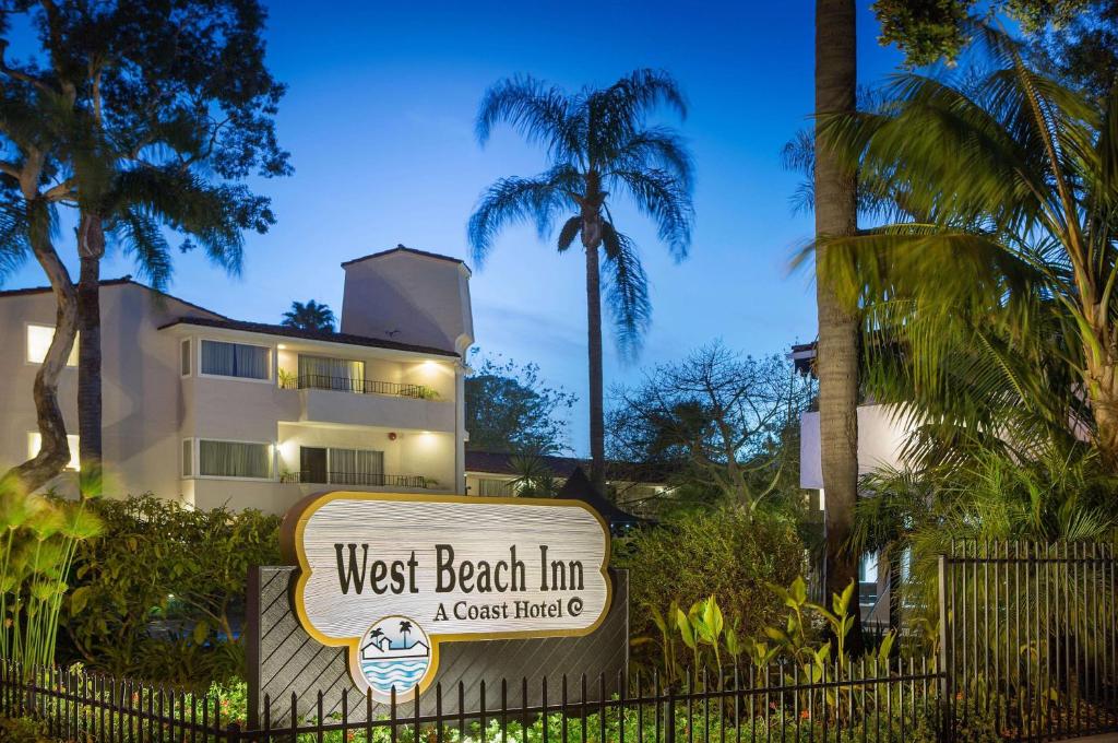 uma placa de pousada de praia oeste em frente a um edifício em West Beach Inn, a Coast Hotel em Santa Bárbara