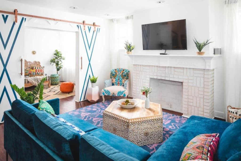 ein Wohnzimmer mit einem blauen Sofa und einem Kamin in der Unterkunft Parkfront Lux in Atlanta