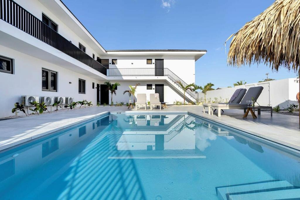 a swimming pool in front of a house at Villa Valena Apartment 1 with Cooling Pool in Kralendijk