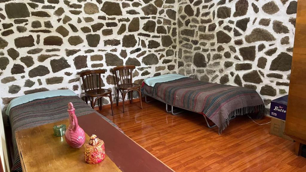 una camera con un letto e un tavolo in una parete finta di Bitro House a Pogradec