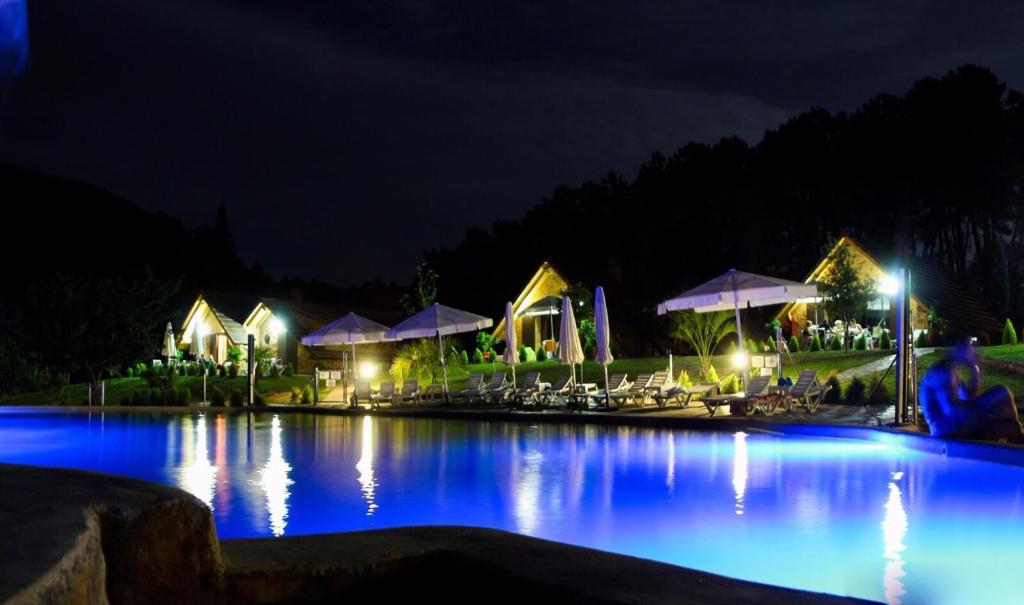 una piscina por la noche con luces azules en Complejo Rural La Coronilla, en Jarandilla de la Vera