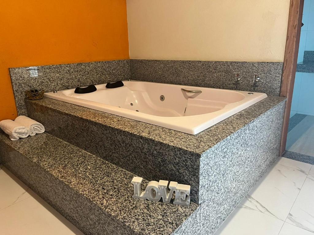 a bath tub sitting on a counter in a bathroom at Pousada Flor de Pequi in Serra do Cipo