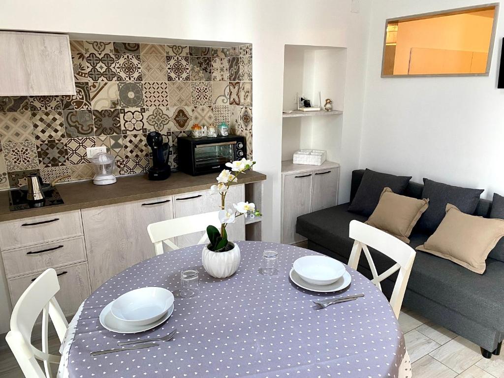 eine Küche und ein Wohnzimmer mit einem Tisch und einem Sofa in der Unterkunft Casa Cecilia - Puglia Mia Apartments in Monopoli