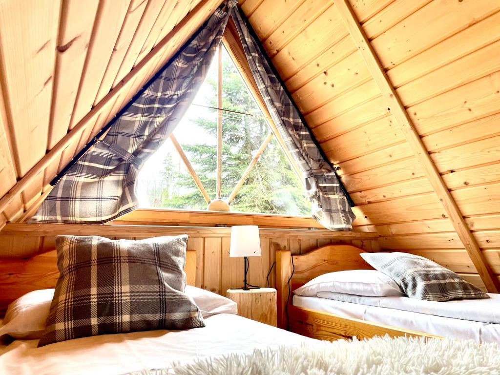 1 dormitorio con 2 camas y una ventana en una cabaña en Domek Góralski W Ogrodzie, en Małe Ciche