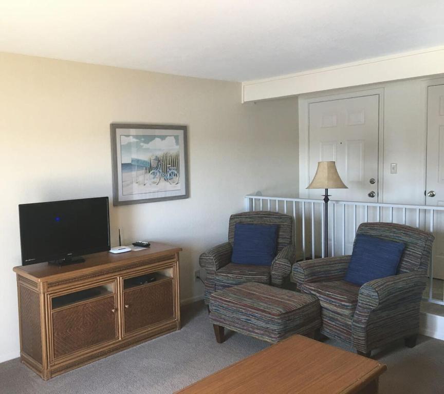 a living room with two chairs and a flat screen tv at Lake View Condo with Pool and Hot Tub close to Grand Glaize Bridge at Lake Ozarks in Osage Beach