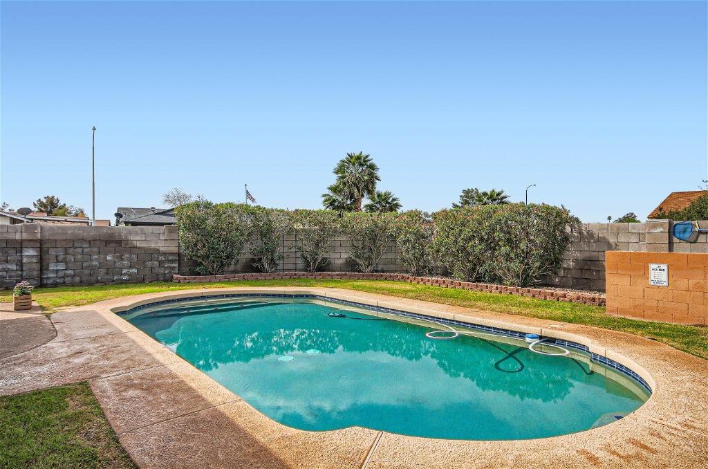 a small swimming pool in a yard with a fence at Arizona Daydream with Private Pool plus EV Charger in Chandler