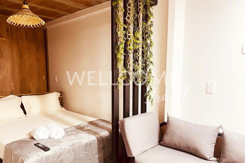 um quarto com uma cama e uma cadeira em Lotus Loft Itagui em Itagüí