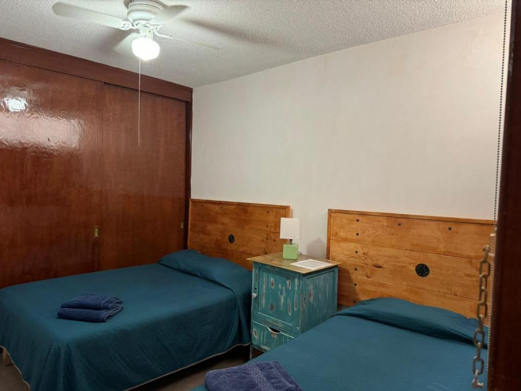 a bedroom with two beds and a ceiling fan at Casona Luciérnaga-Casa de Huéspedes in León