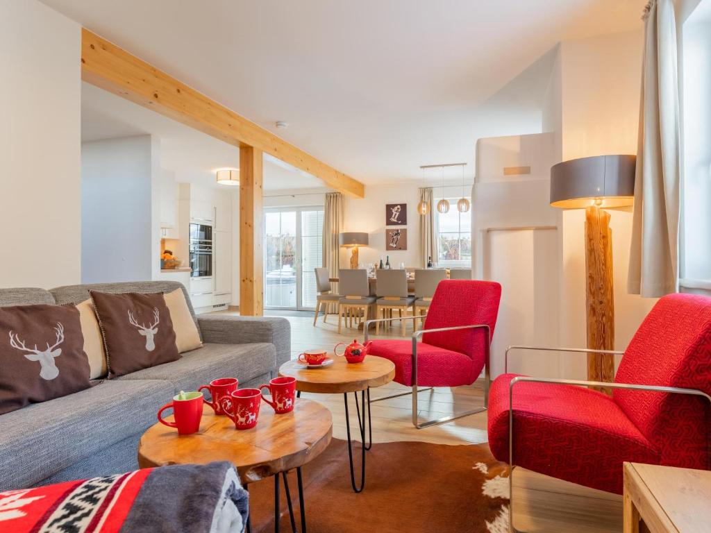 a living room with a couch and red chairs at Chalet Bergblick in Sankt Margarethen im Lungau