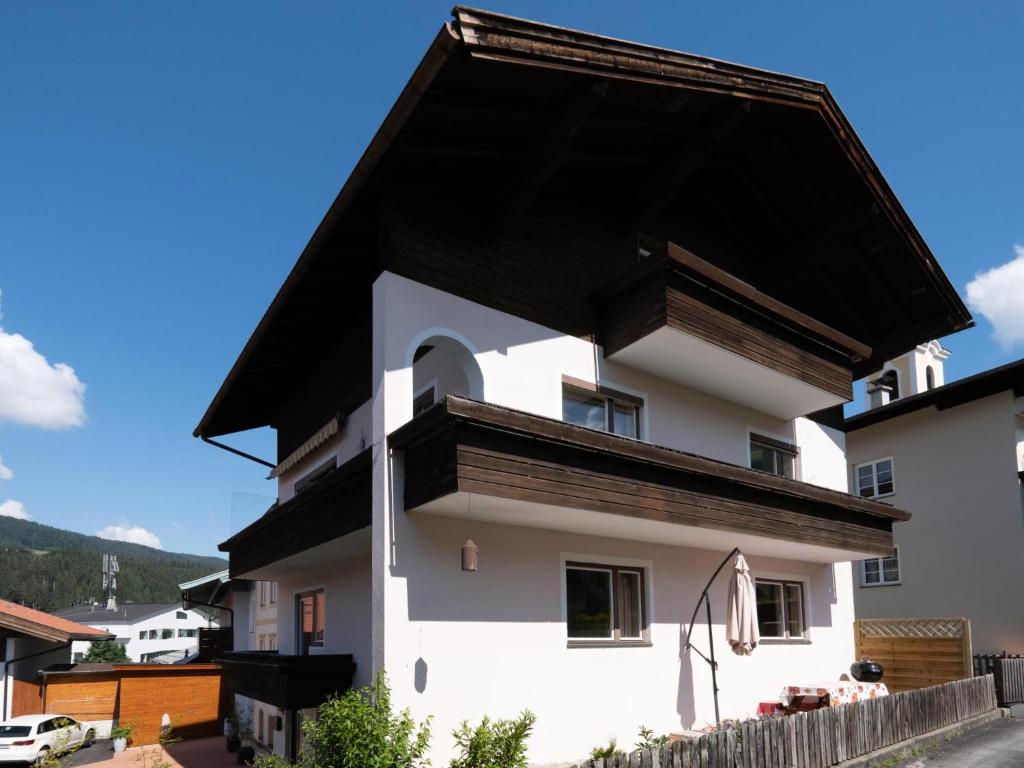 ein weißes Haus mit schwarzem Dach in der Unterkunft Chalet Stitzgassl in Hopfgarten im Brixental
