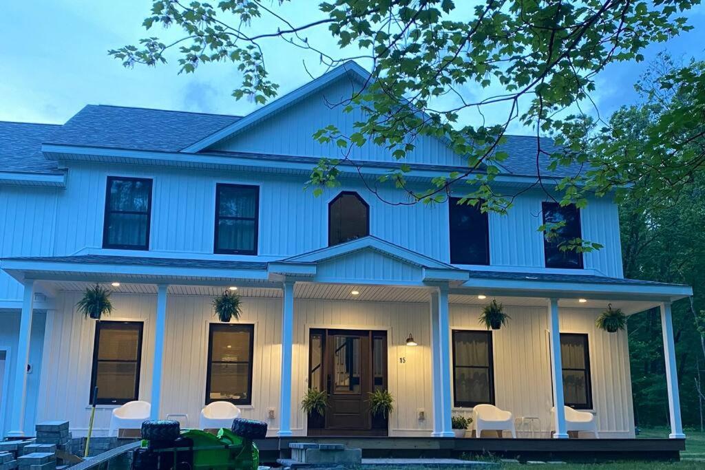 una casa blu con colonne e finestre bianche di Top of the Stretch Oasis a Saratoga Springs