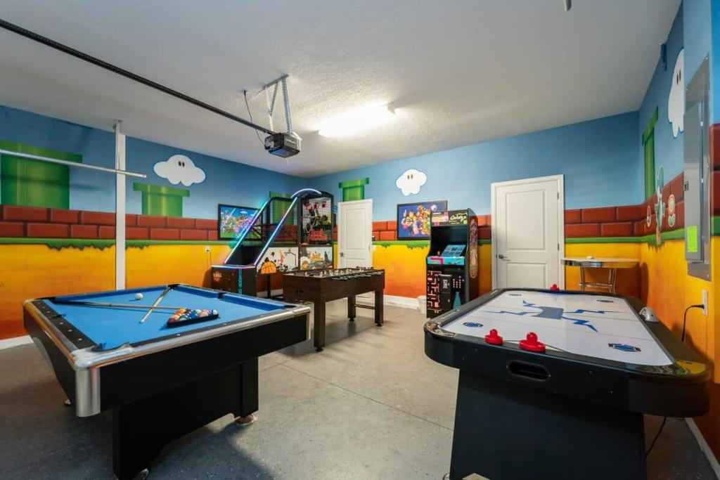 une salle avec deux billards et une salle de jeux avec un espace de rangement. dans l'établissement Charming 9BR Villa w Theme & Game Rooms by Disney, à Kissimmee