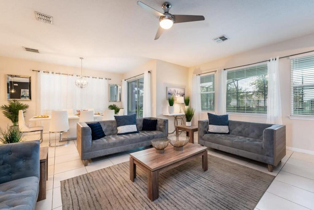 a living room with two couches and a table at Gorgeous 7BR Villa w Pool Games Resort Access in Kissimmee