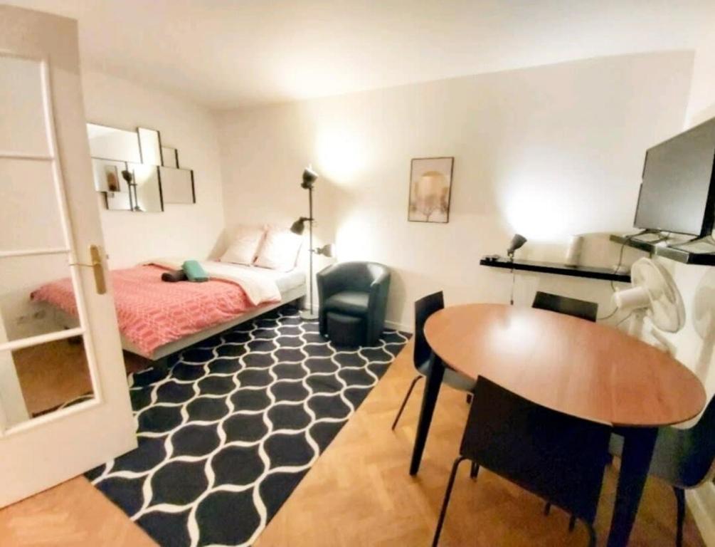 une chambre avec un lit, une table et un bureau dans l'établissement The Unforgetable at Canal de l'Ourcq, à Paris