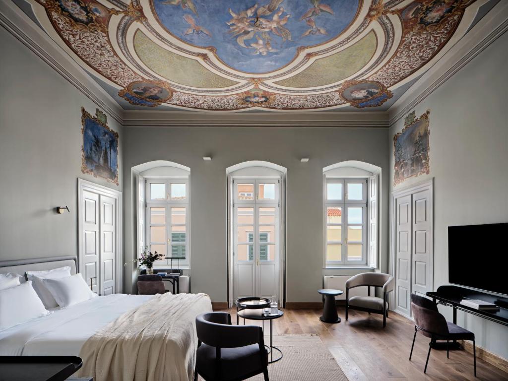 una camera con un grande letto e un soffitto di Argini Syros a Ermoupoli