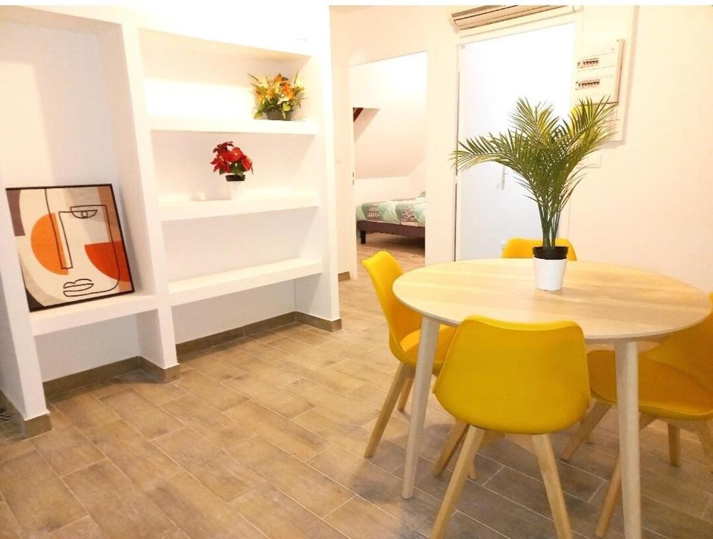 uma sala de jantar com uma mesa e cadeiras amarelas em La Chaleureuse crepes et raclettes apres travail em Moissy-Cramayel