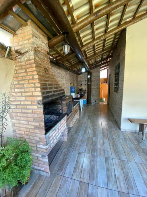 a room with a brick fireplace in a building at Casa das orquídeas in Santana do Riacho