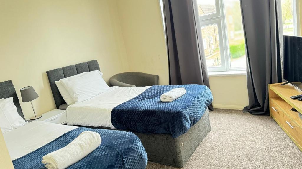 a hotel room with two beds and a television at Luxury Living at Hampden Gardens - Stunning Two-Bedroom Flats from Fran Properties! in Buckinghamshire