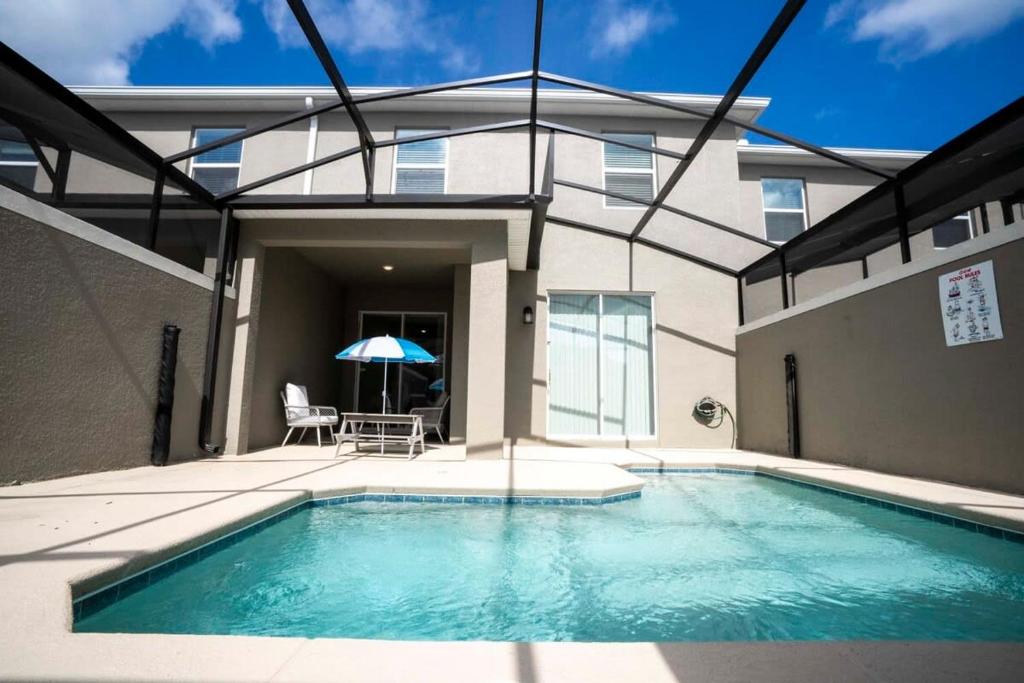 a swimming pool in front of a building at Gorgeous 4 Bedroom w Screened Pool Close to Disney 2653 in Kissimmee