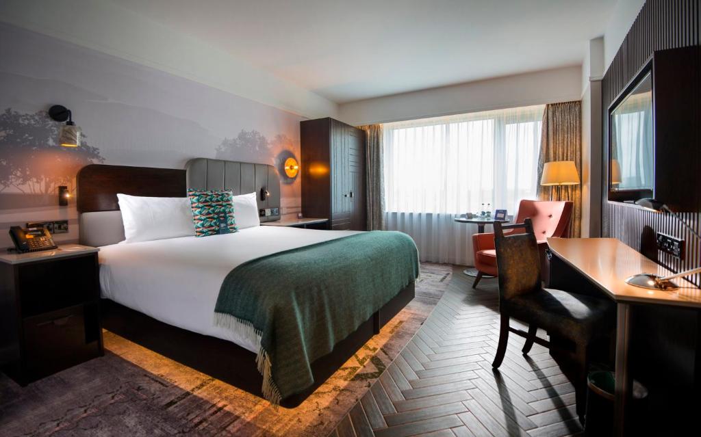 a hotel room with a large bed and a desk and a desk at Crowne Plaza Dublin Blanchardstown, an IHG Hotel in Blanchardstown