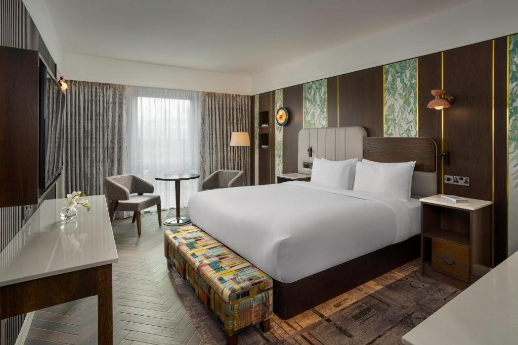 um quarto de hotel com uma cama grande e uma secretária em Crowne Plaza Dublin Blanchardstown, an IHG Hotel em Blanchardstown