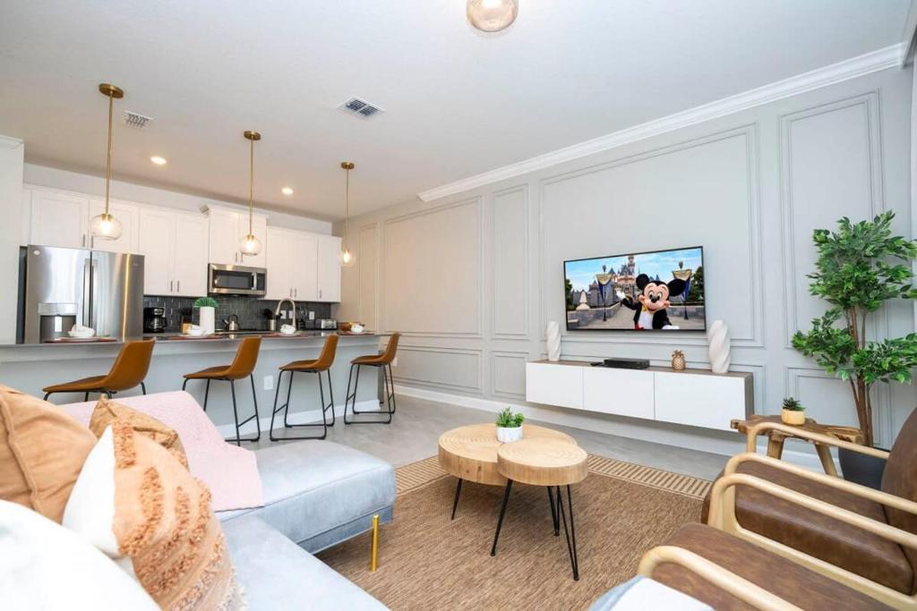 ein Wohnzimmer mit einem Sofa und einer Küche in der Unterkunft WonderFul 4Bd Near Disney w Pool at StoreyLake 2557 in Kissimmee