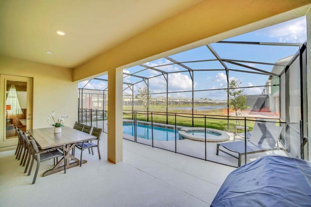 - une chambre avec vue sur la piscine depuis une maison en verre dans l'établissement Stunning 12Bd Sleeps 25 w Pool Close to Disney at Veranda Palms 4405, à Kissimmee