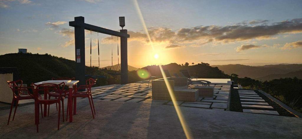 - une table et des chaises sur une terrasse avec vue sur le coucher du soleil dans l'établissement Hacienda JM's, 