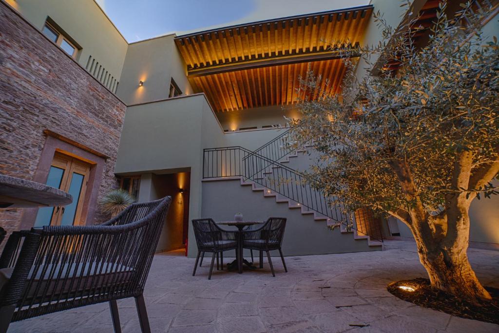 eine Terrasse mit einem Tisch, Stühlen und einer Treppe in der Unterkunft HOTEL CASA ARANZAZU SAN LUIS POTOSI in San Luis Potosí