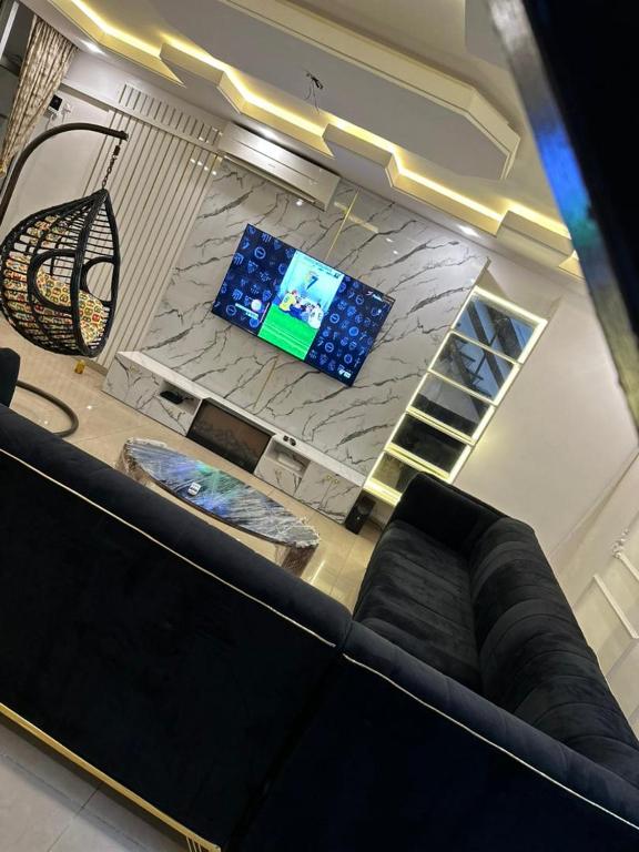 uma sala de estar com um sofá e uma televisão em Frontline em Lagos