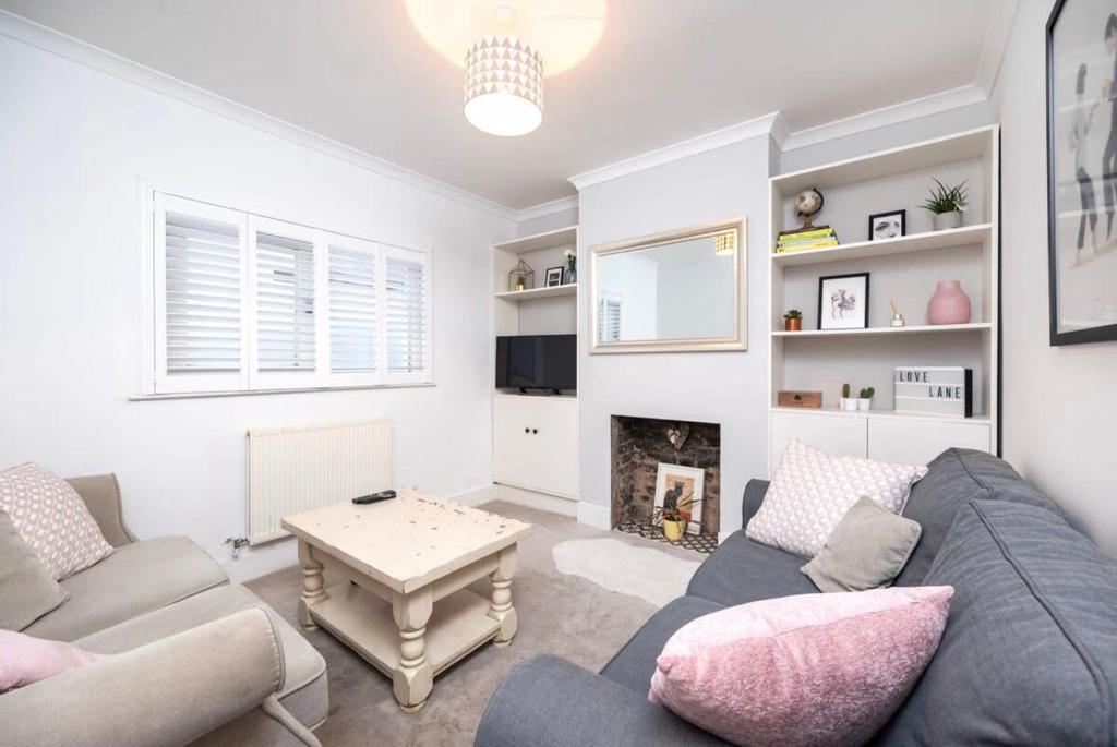 uma sala de estar com um sofá e uma lareira em Lovely 2BR house in Norwood Junction London em Londres