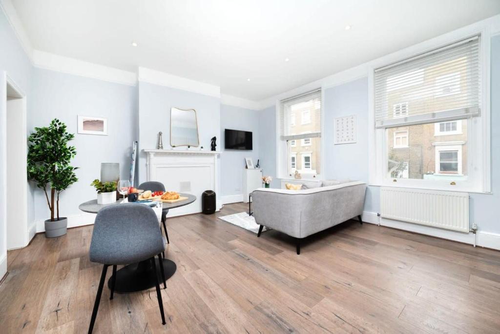 a large living room with a tub and a table at Cozy 1 bedroom flat in Greater London in London