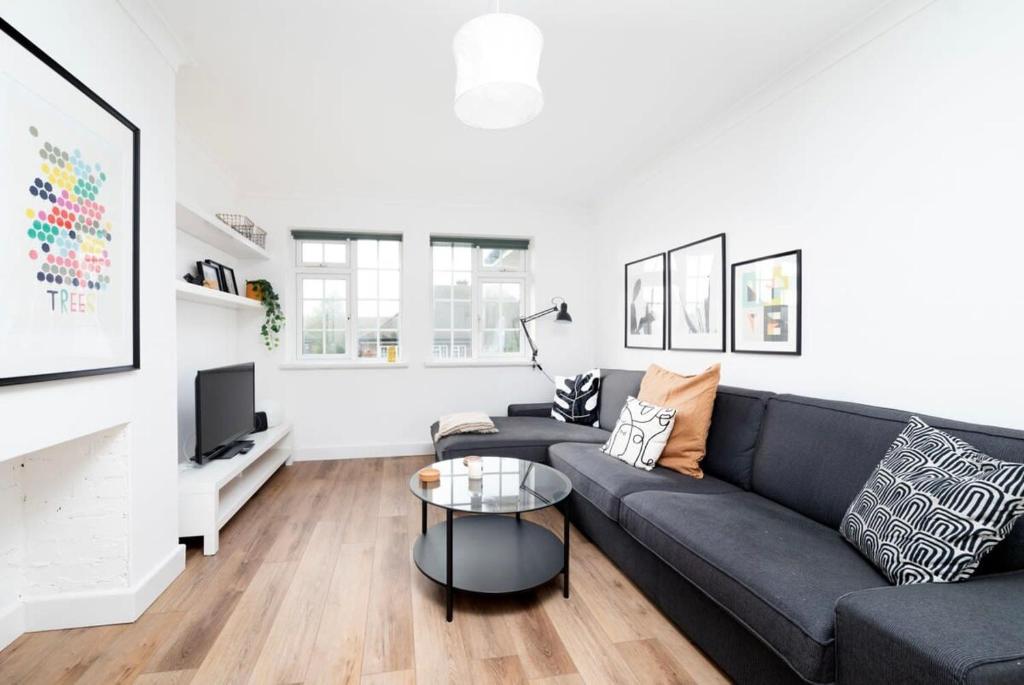 a living room with a couch and a table at Stylish 2BR Oasis Steps from Wembley Stadium in London