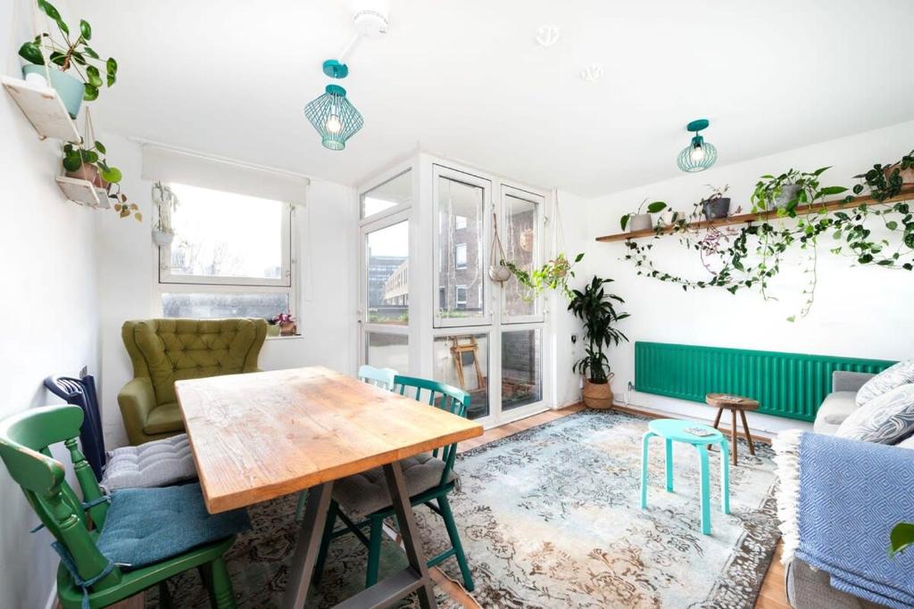 een woonkamer met een tafel en stoelen bij Cozy 1-Bedroom Oasis with Balcony in London's Heart in Londen