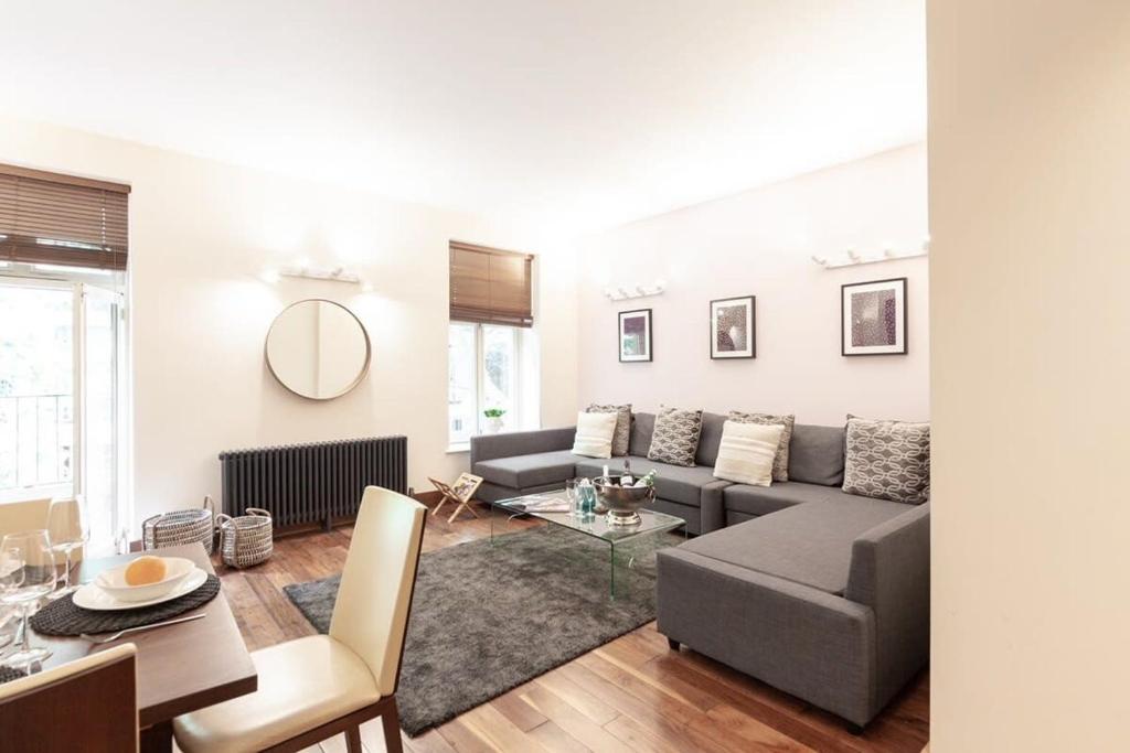 a living room with a couch and a table at Modern and comfortable air-conditioned 2BR flat in London