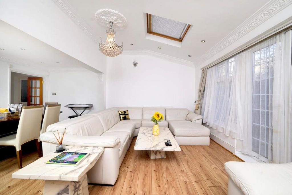 a living room with a white couch and a table at Chic 2BR Home - Eats and Sights Closeby in London