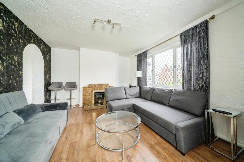 a living room with a couch and a table at Charming 3BR House With Free Parking and Garden in Hounslow