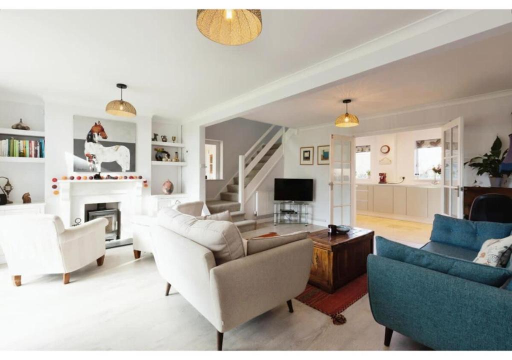 a living room with white furniture and a fireplace at 3BR Cheltenham Home - Elegance and Comfort in Cheltenham