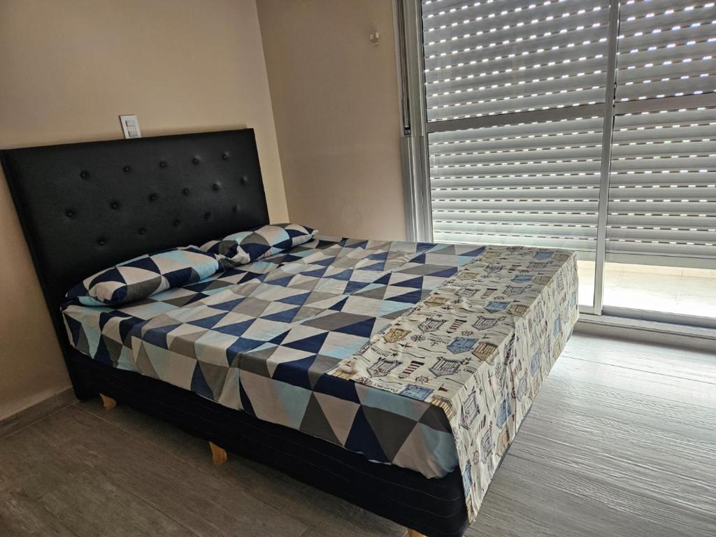 um quarto com uma cama com um cobertor xadrez em Feels like home - La Boca em Buenos Aires