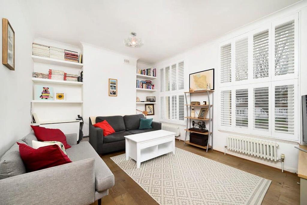 a living room with a couch and a table at Chic and comfortable London 2BR home in London