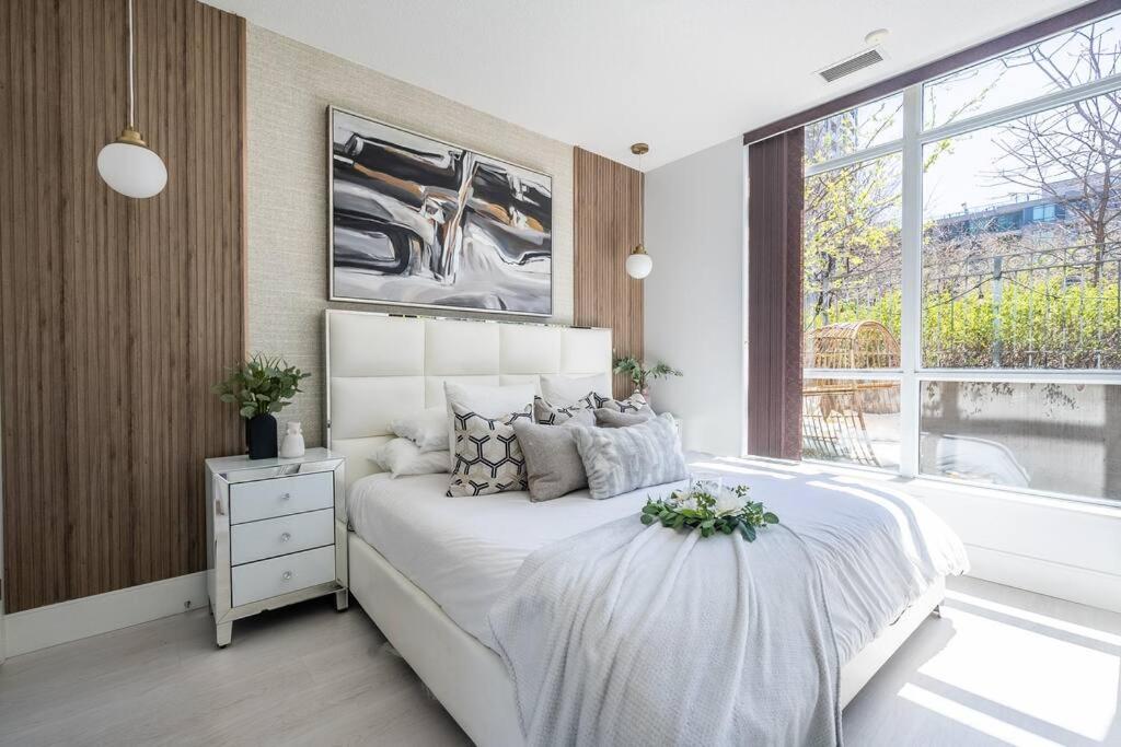a bedroom with a large white bed and a window at Luxury Suite With Private Terrace Downtown Toronto in Toronto