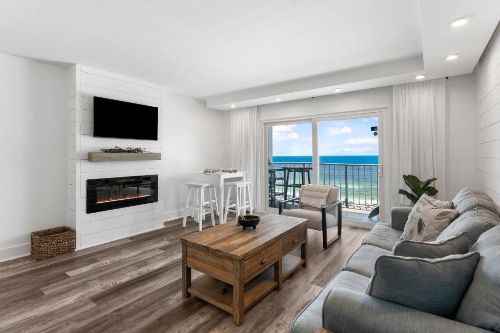 sala de estar con sofá, chimenea y mesa en The Summit 808 - Luxury Beach Resort Condo - Beachfront - Incredible Views - BEACH CHAIRS AND SUNSHADE Provided In Condo, en Panama City Beach