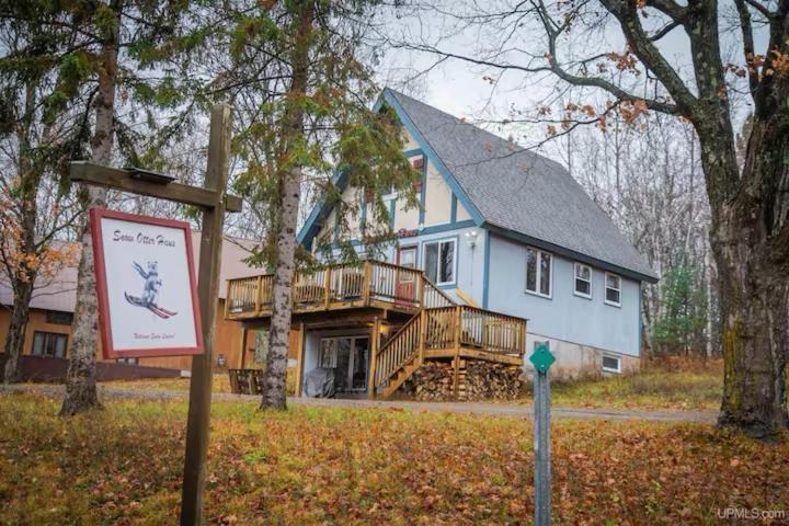 a large blue house with a porch and a sign at Snow Otter Haus - 1 in Bessemer
