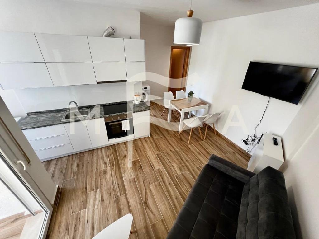 een woonkamer met witte kasten en een tafel bij Royal Cliff 504 in Durrës