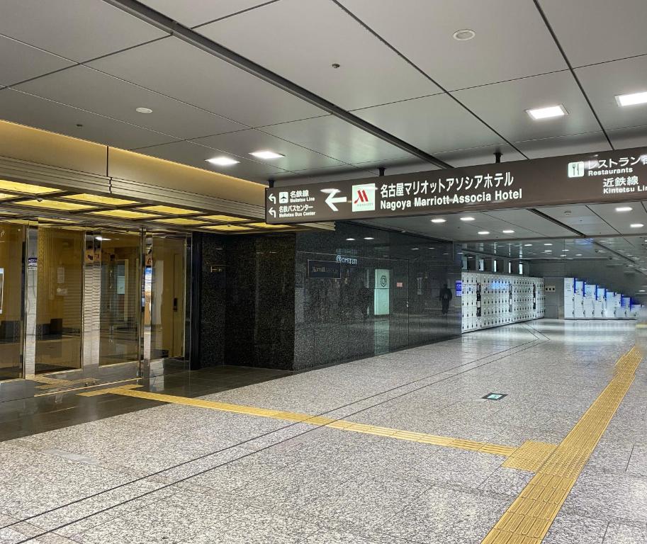 an empty airport terminal with signs on the ceiling at Nagoya Marriott Associa Hotel in Nagoya