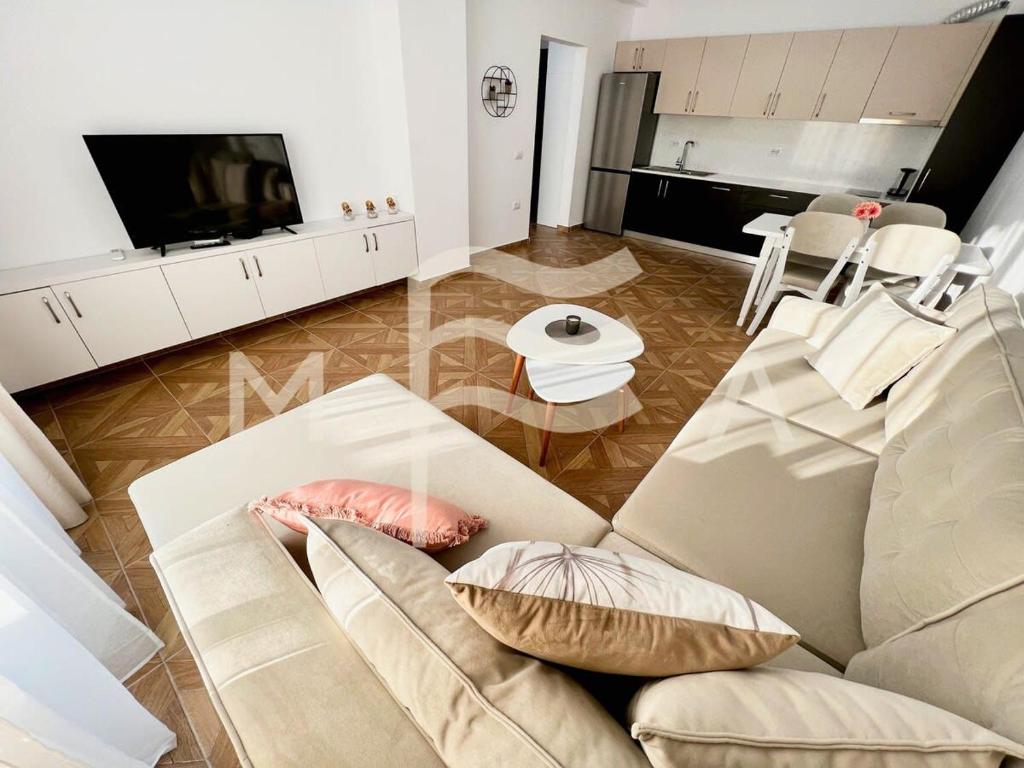 uma sala de estar com um sofá e uma televisão em Harmony 591 em Durrës