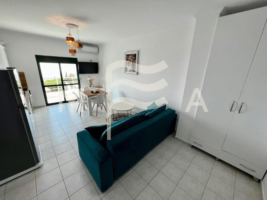 ein Wohnzimmer mit einem blauen Sofa und einem Tisch in der Unterkunft Nouveau 623 in Durrës