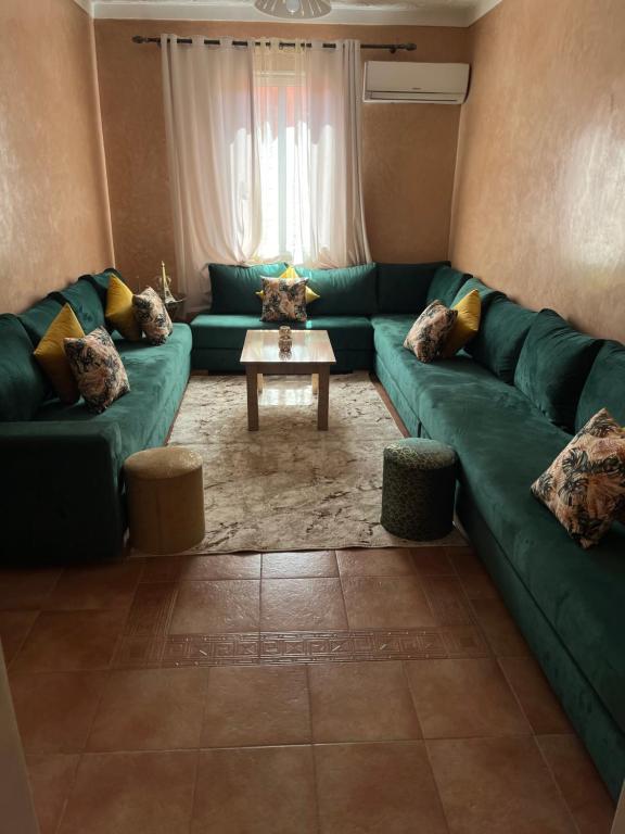sala de estar con sofá verde y mesa en Superbe appartement au porte de gueliz, en Marrakech
