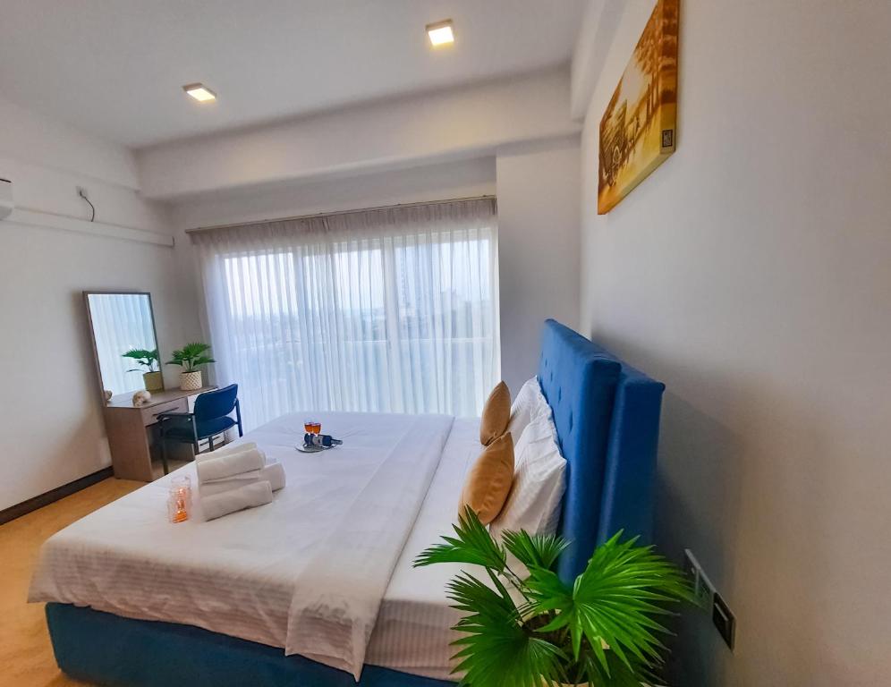 尼甘布的住宿－Sea Wave Luxuy Apartment，一间卧室配有一张大床和蓝色床头板